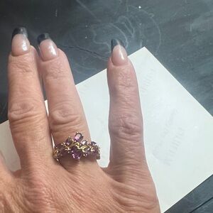 A .925 sterling silver ring with purple gemstones in floral design